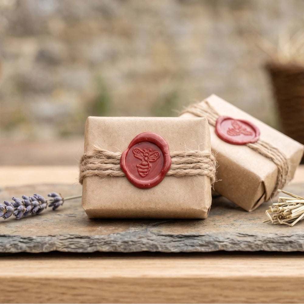 Mini-savons artisanaux Sève & Cendre sur ardoise brute avec une branche de lavande naturelle.