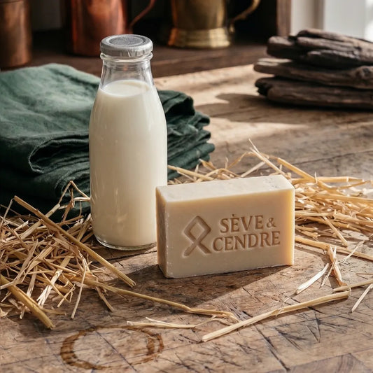 Brique de savon brut Sève & Cendre gravée posée sur paille avec bouteille de lait de chèvre et linge vert